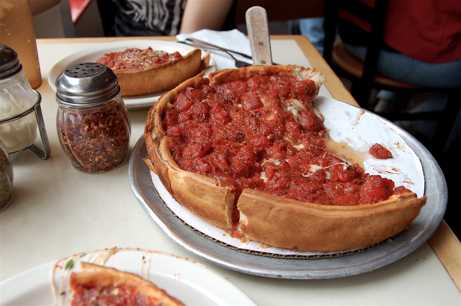 Chicago deep-dish pizza with a tall crust and tomato-topped filling