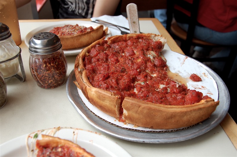 Chicago deep-dish pizza in a round metal pan