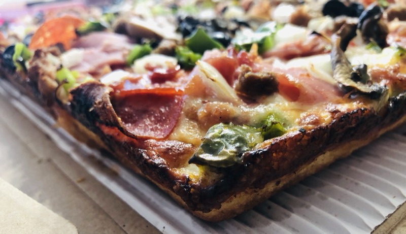 Rectangular Detroit-style pizza with a crisp cheese edge