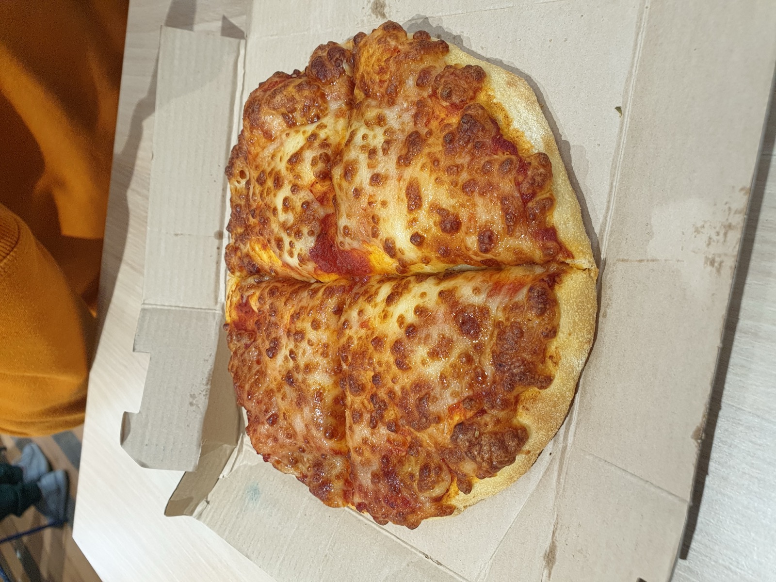 Round pan pizza with a thick golden crust, tomato and melted cheese