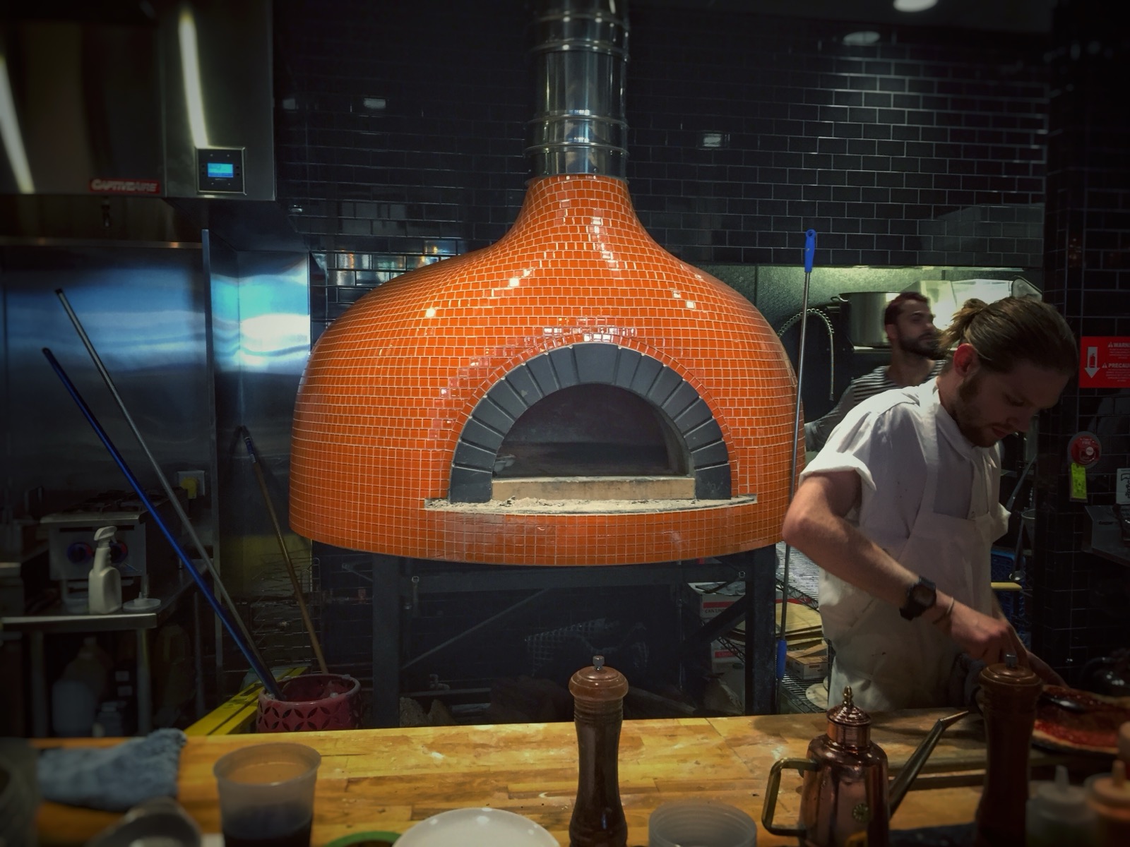 A wood-fired pizza oven with visible flame